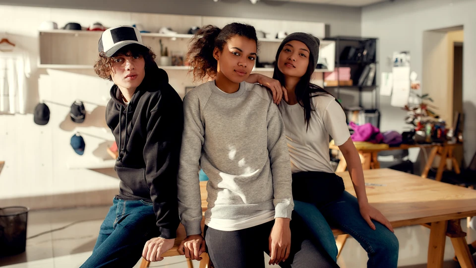 Trois jeunes femmes posent ensemble dans un atelier créatif moderne