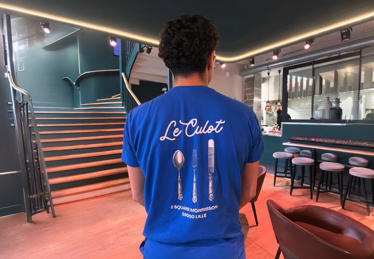 Composition à plat de vêtements de sport féminins sur fond blanc incluant veste coupe-vent marine à capuche avec cordons roses, débardeur rose technique à dos nageur, short de sport bleu marine à liserés blancs et cordons rayés