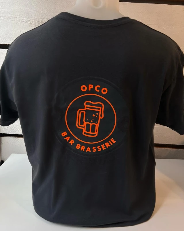 Intérieur lumineux avec mannequin présentant un t-shirt bordeaux sur parquet bois clair près de fenêtres voilées